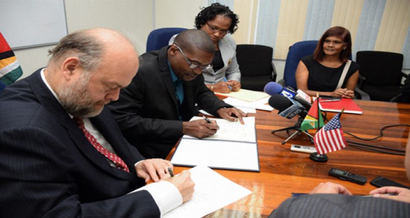 Minister of Public Infrastructure David Patterson and
U.S. Ambassador to Guyana Perry Holloway sign the
memorandum of agreement between the GCAA and
USA-TSA for support and cooperation in developing
capacities and expertise in civil aviation
