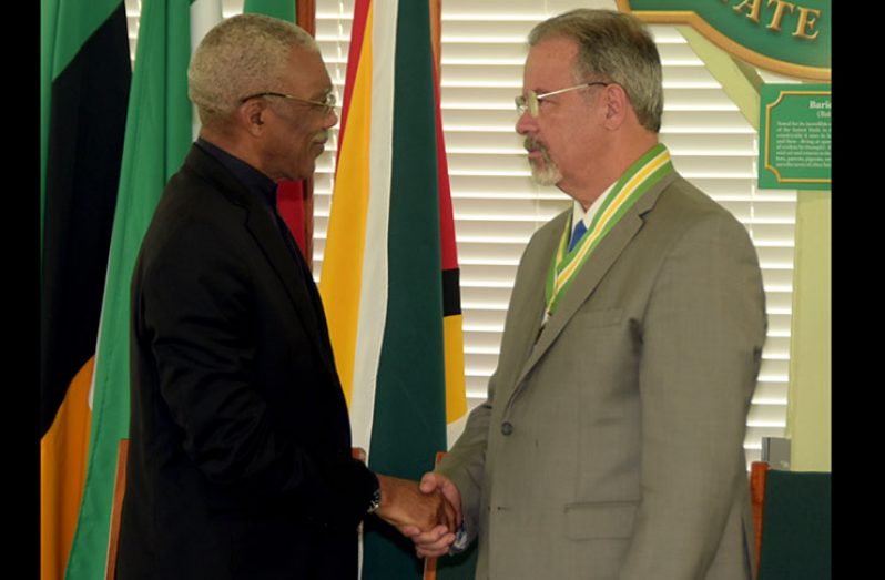 President David Granger congratulates Brazilian Minister of Defence, Mr. Raul Jungmann, after conferring him with the Cacique Crown of Honour
(Adrian Narine photo)