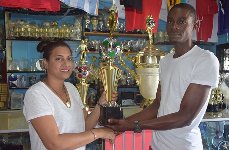 Managing Director at Trophy Stall, South Road, Bourda, Devi Sunich (left) hands over one of the trophies to proprietor of Xtreme Clean and Maintenance, Roger Cambridge, yesterday.