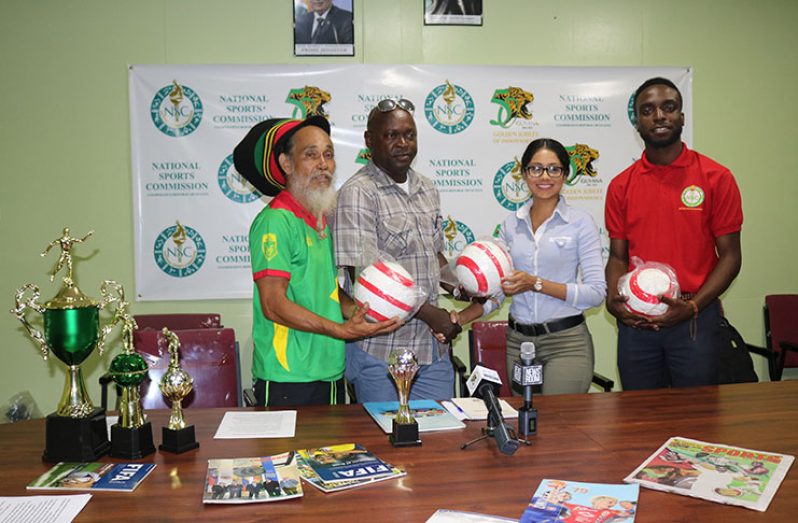 Miss Chontelle Sewett of Germans Restaurant hands over Tournament ball to Mark Young (Tournament Coordinator).At far right is Assistant Director for Sport, Brian Lewis and at far left is the conceptualiser of the tournament, Ras Wadada.