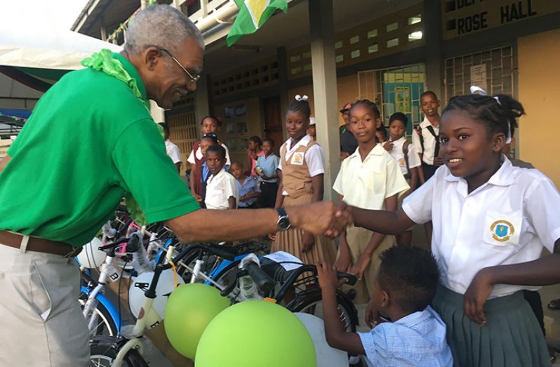 A student from the Lower Corentyne Secondary School receives a bicycle from President Granger
