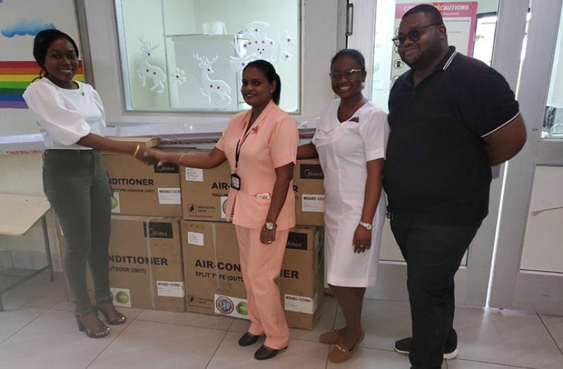 Tiffany Greene hands over the AC units to GPHC Pediatric Unit Junior Supervisor, Shivani Ramdehol