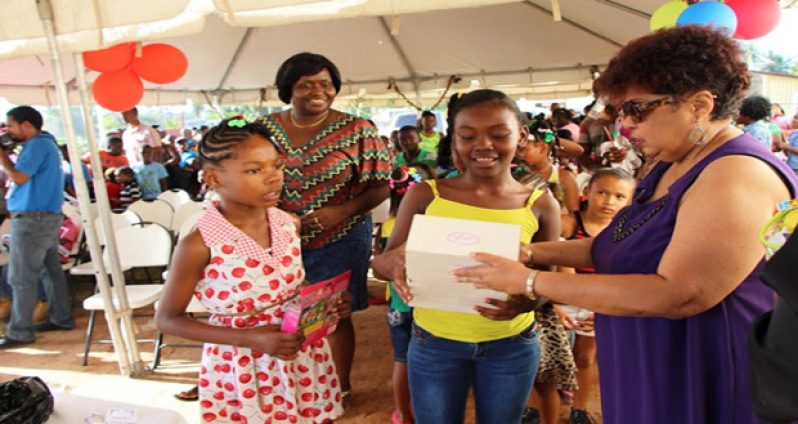 Minister Ally presents a gift to this excited little girl