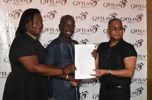 giftland Giftland Mall Chairman Roy Beepat, Sophia resident Odessa Primus and Pattensen Development Council Chairman Colin Marks display the signed contract on Friday