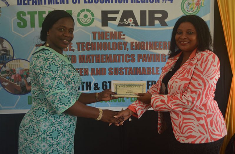 GPL Public Relations Officer Shevon Sears presenting a cheque to Region Four Acting Regional Education Officer (REDO) Tiffany Harvey