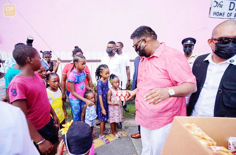 President Dr Irfaan Ali distributing gifts to children of Albouystown