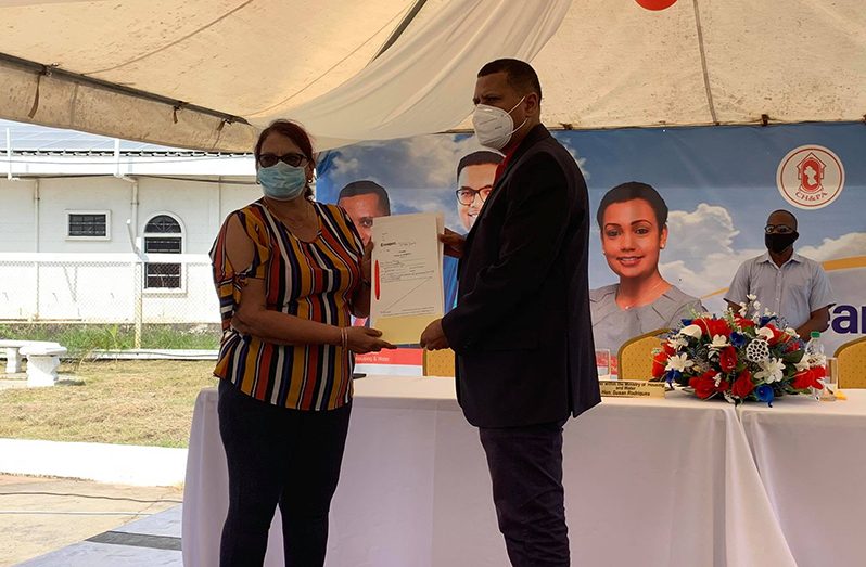 Minister of Housing and Water, Mr. Colin Croal hands over a transport to Gargie Devi Shiwkumar of Adelphi, Canje, Region Six