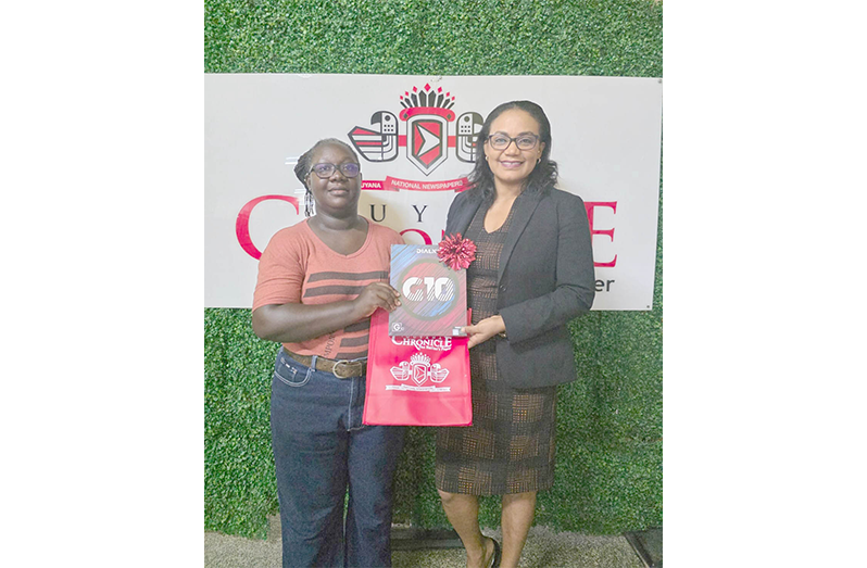 Shaniece Williams receives her prize from the Marketing and Circulation Manager of the GNNL, Beverly Roberts