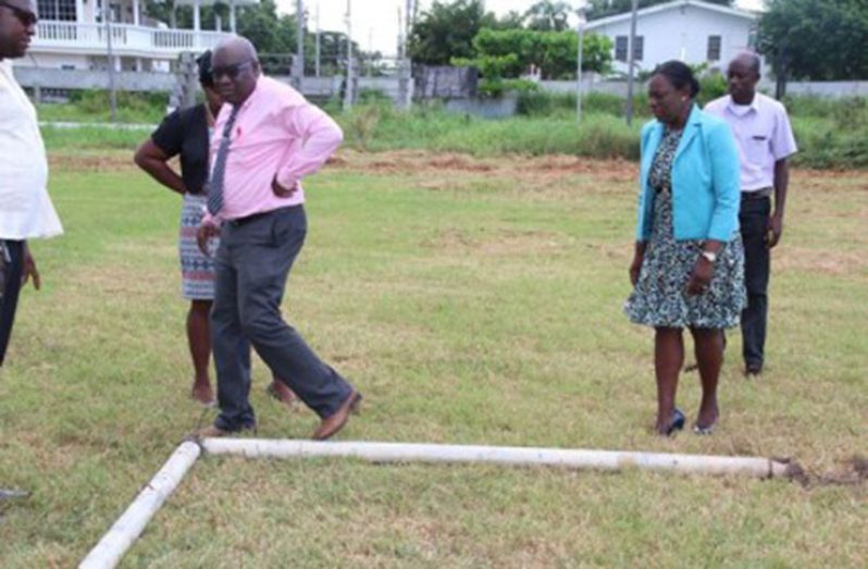 Minister of Education, Hon. Nicolette Henry and Chief Education Officer, Marcel Hutson inspecting the area and the goal post where the tragic incident occurred