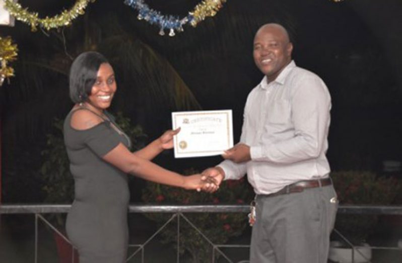 A participant receiving her certificate from Enmore Sugar Estate Manager, Curbette Victorine