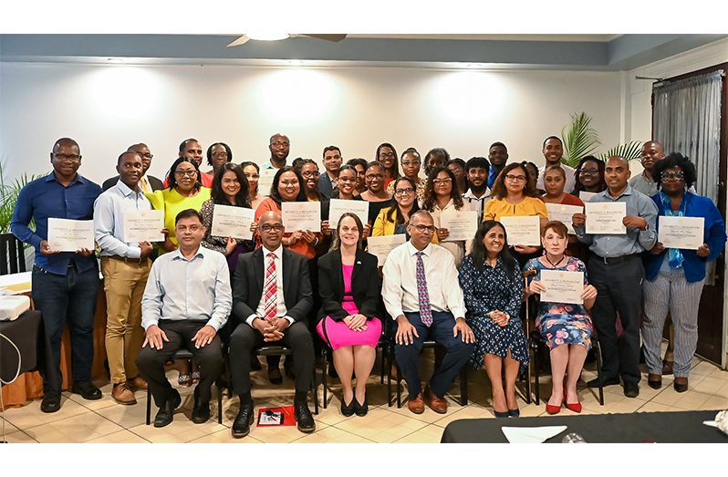 Minister of Health, Dr Frank Anthony (seated front), and other officials surrounded by graduates of the programme (Delano Williams photo)