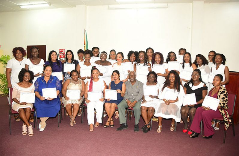 The BIT Certificate in Early Childhood Development graduates pose with their certificates, with Minister within the Ministry of Social Protection, Keith Scott (sitting, fifth from right) (Adrian Narine photo)