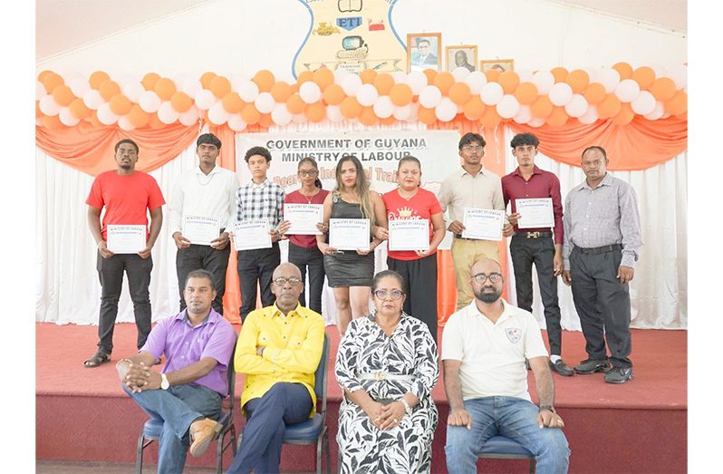 Minister of Labour Joseph Hamilton (second from left), an official and some of the graduates