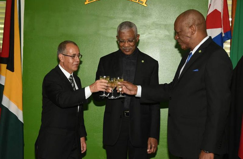 President David Granger and Minister of State, Joseph Harmon share a toast with newly-accredited Cuban Ambassador, Narciso Reinaldo Armador