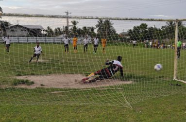 Agricola Red Triangle’s Gordon Grant scores from the penalty spot against Javier Greene