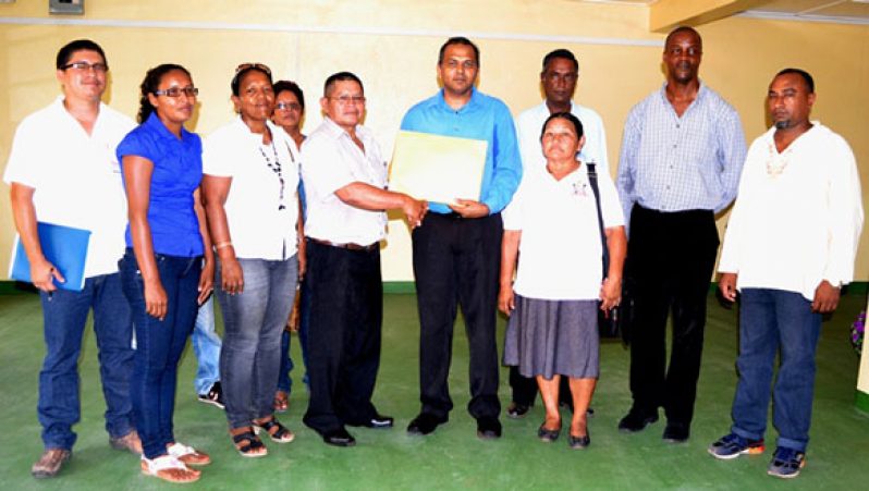 Minister of Culture Youth and Sport, Dr. Frank Anthony presents grants for the ground enhancement project to Region 9 Chairman, Wilson Lorentio