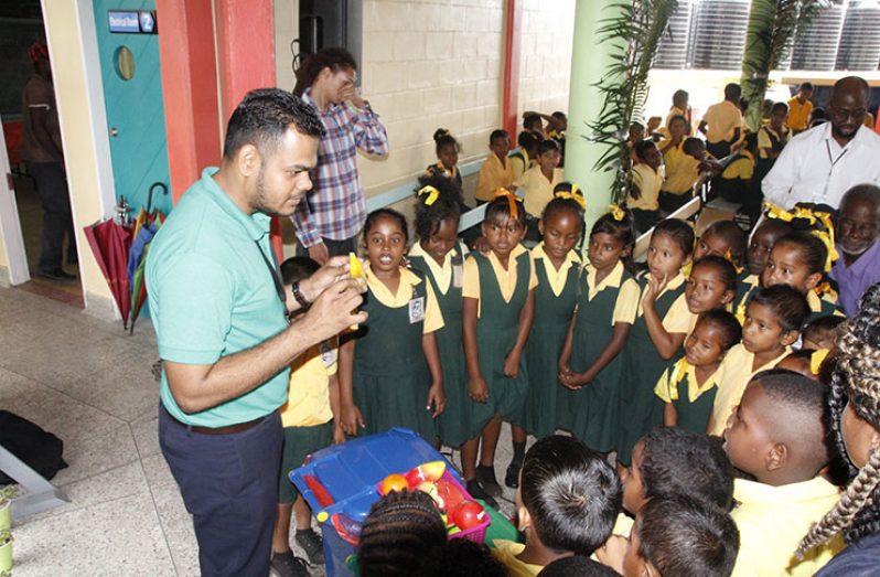 A Ministry of Communities official teaching the students of Yarrowkabra Primary School how to use the bins. (Ministry of Education photo)
