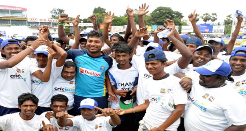 Everybody loves Sanga: Kumar Sangakkara poses with the ground-staff of P Sara Oval, at the end of his final Test in Colombo on the fifth day.