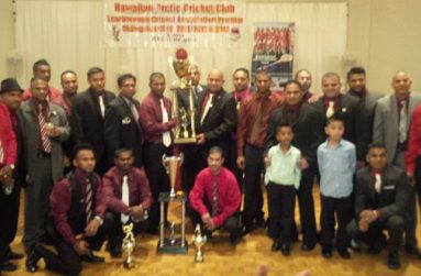 HACC president Archie Mohan and skipper Hemnarine Chattergoon pose with the Premier League trophy in the presence of other players, officials and supporters.