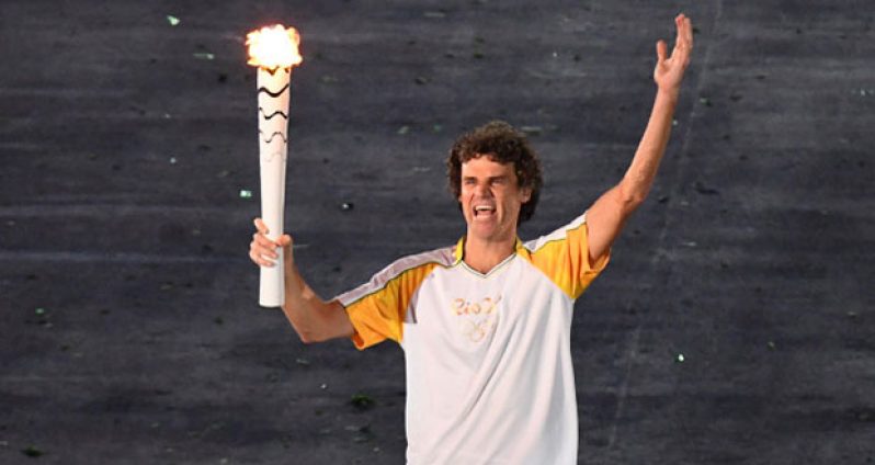 Brazilian tennis player Gustavo Kuerten carries the Olympic flame during the opening ceremony of the Rio 2016 Olympic Games at the Maracana stadium in Rio de Janeiro last night. /AFP/Getty Images)
