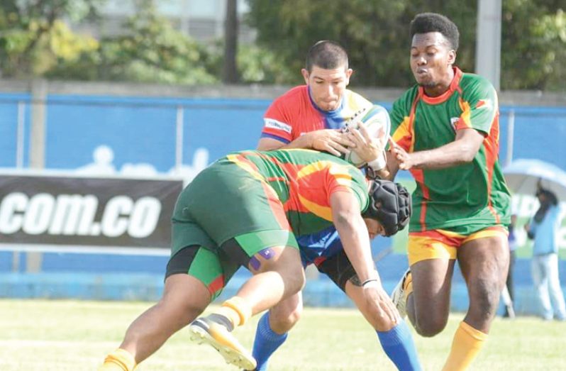 Guyana's Rondell 'Bull' McArthur executes a tackle with some assistance from Lancelot Adonis against Colombia.