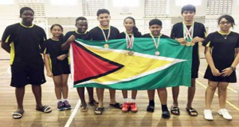 The victorious badminton team proudly display the Golden Arrowhead after their successful tournament in Suriname.