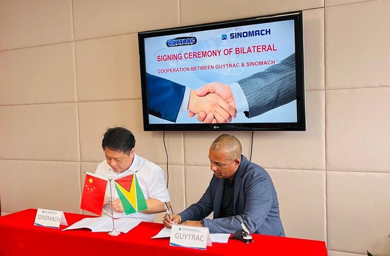 GUYTRAC representative, Sharoj Singh, and Spencer Bao, Sales manager for Latin America and Africa, signing the multibillion-dollar contract in Chenzhou, China