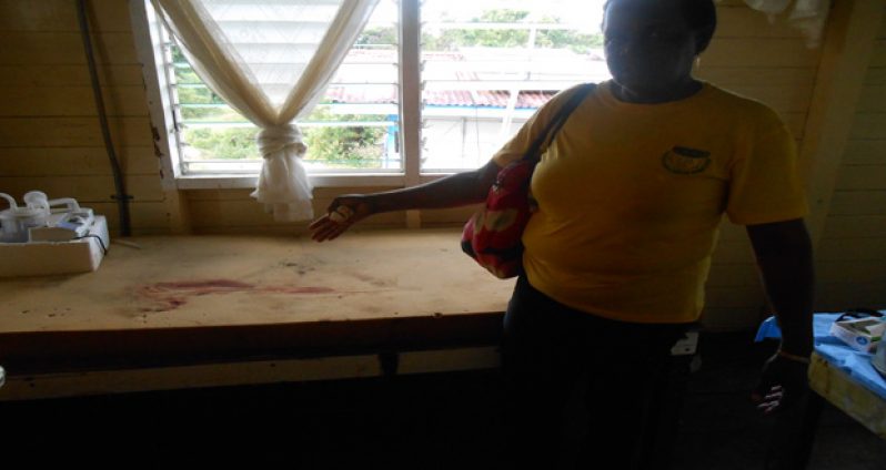 A woman points to the blood-stained mattress at the Baramita health institution.