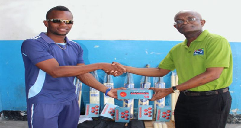 Kellon Carmichael, captain of MSC, receives cricket gear from Public Relations Manager of FFP, Wayne Hamilton.