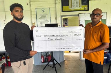 Recardo Fiedtkou (left) collects the symbolic cheque from the GCC’s Bar Manager Rajendra Shamlall