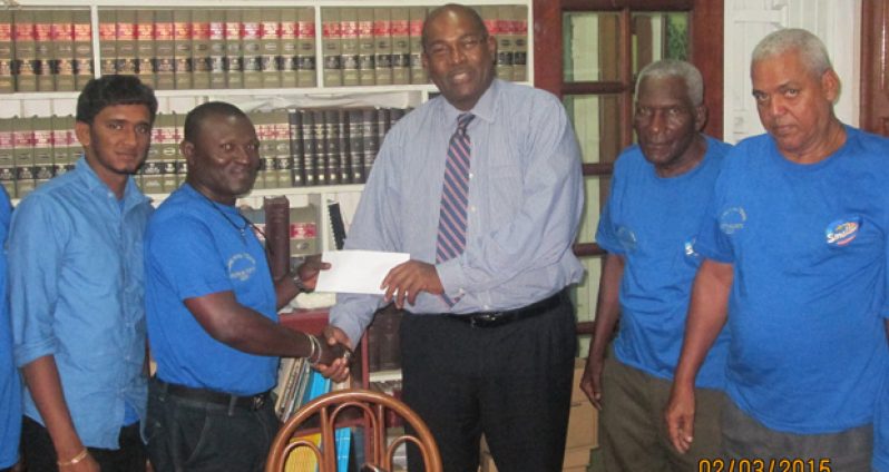 Nigel Hughes presents donation to RHTY&SC assistant secretary Franklyn Ross.