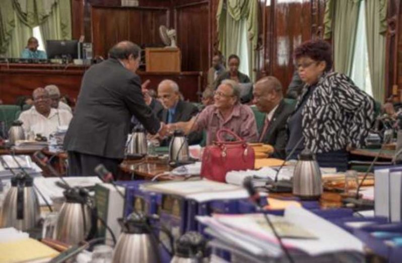 Prime Minister Moses Nagamootoo congratulates newly appointed Public Service Minister, Dr Rupert Roopnaraine in the National Assembly chambers