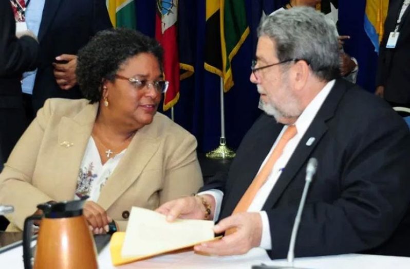 Prime Minister Mia Amor Mottley handing over the reins to incoming chairman, Prime Minister Dr. Ralph Gonsalves of St. Vincent and the Grenadines