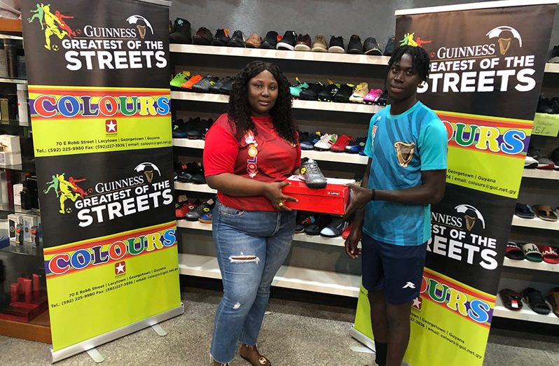 Laing Avenue’s Bevney Mark, the MVP of the Guinness ‘Greatest of the Streets’ Georgetown Championship receives his prize from Safisha Hope, Colours Boutique Supervisor
