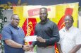 Petra’s Co-Director Troy Mendonca (left) receiving sponsorship contribution from ANSA McAL’s Lucozade Business Head Triston Freeman in the presence of Troy Peters. (Japhet Savory photo)