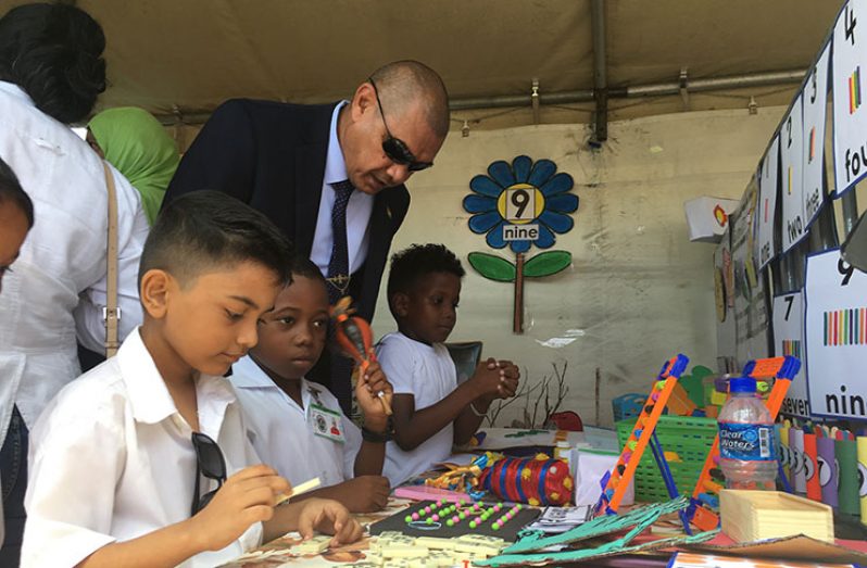 Minister of Business, Haimraj Rajkumar, interacts with children who were paying keen attention to learning materials