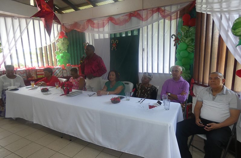Former PNCR leader Robert Corbin addresses the gathering. From left: Minister within the Ministry of Public Infrastructure Annette Ferguson; Minister of Social Protection Amna Ally; Minister of Public Health Volda Lawrence; Corbin’s wife Carol and his sister Haslyn; Minister of Communities Ronald Bulkan and Minister of Social Cohesion George Norton