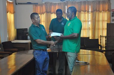 Guyana Volleyball Federation president John Flores (left) receives the cheque from GOA secretary-general, Hector Edwards.