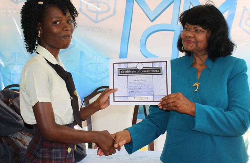Former Regional Education Officer Shafiran Bhajan hands over a certificate of commitment to a student who will sit the Caribbean Secondary Education Certificate Examinations (CSEC) next year