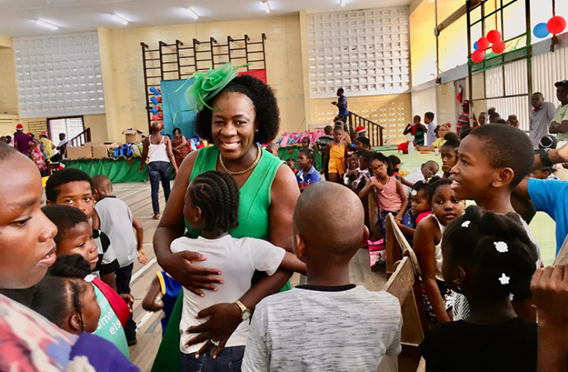 Minister of Education Nicolette Henry is greeted with a hug by a child