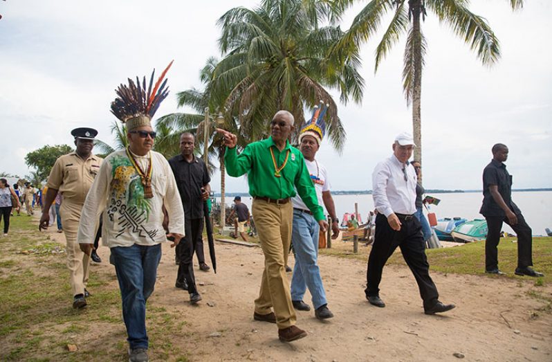 President David Granger being escorted by Minister of Indigenous Peoples' Affairs, Mr. Sydney Allicock, in the company of Minister of Social Cohesion, Dr George Norton and other officials