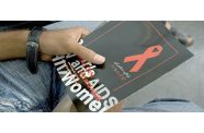 A man holds a brochure about HIV/AIDS as he waits to attend a meeting on the disease in Iran (UNICEF/Shehzad Noorani file photo)