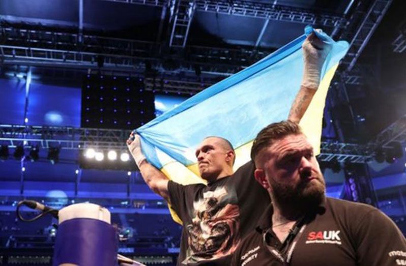 Usyk holds the Ukrainian flag aloft after his victory against Britain's Anthony Joshua at Tottenham Hotspur Stadium in September
