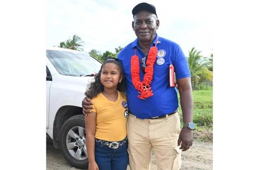 Minister of Home Affairs, Hon. Robeson Benn and nine-year-old Shafeena Ali, a student of Betsy Ground Primary School who had the chance to meet Minister Benn in her home village