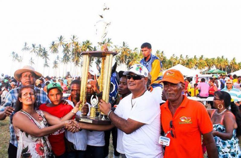 The Prime Minister’s representative Gobin Harbhajan (in white shirt) hands over the winning trophy to representatives of the Nand Persaud Stable.