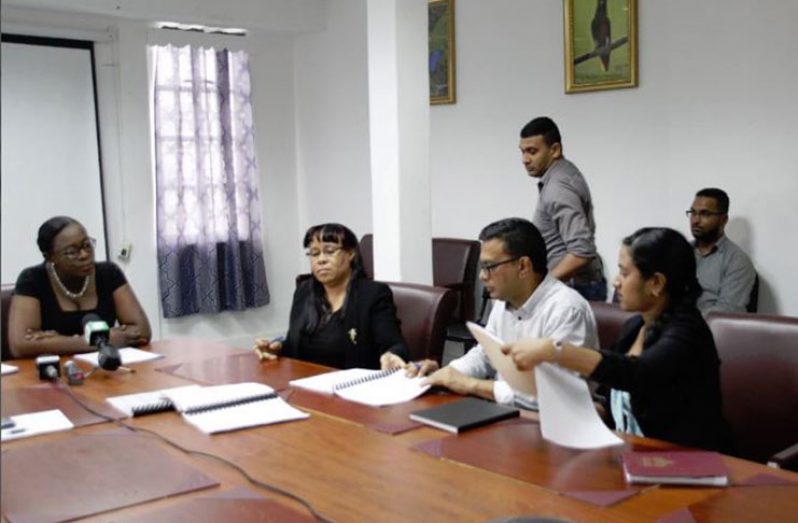 Minister of Education, Nicolette Henry, (left) watches on as Permanent Secretary Adele Clarke (second from left) and Deen Kamaludeen (third from left, sitting) sign the contract on Thursday