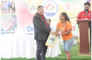 An excited resident picks her lot number with the help of Minister Croal