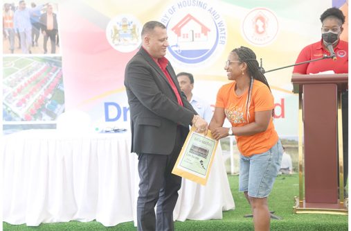 An excited resident picks her lot number with the help of Minister Croal
