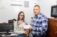 Minister Collin Croal hands over the cash grant cheque to one of his staff at the Ministry of Housing and Water (Housing Ministry photo)