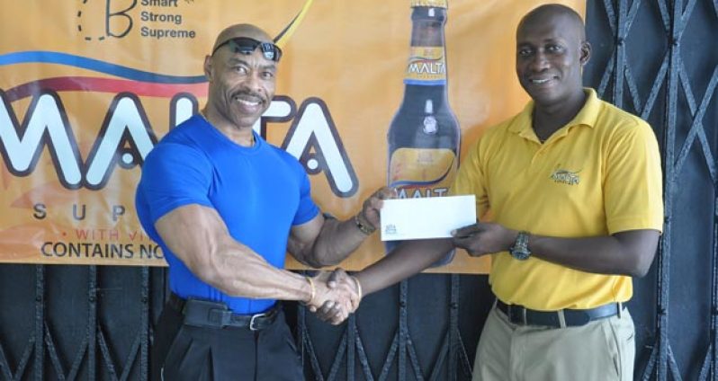 Banks DIH Brand Manager (Non-Alcoholic Malts) Clayton McKenzie (right) hands over the cheque to Hugh Ross, Chairman of the HRC committee.